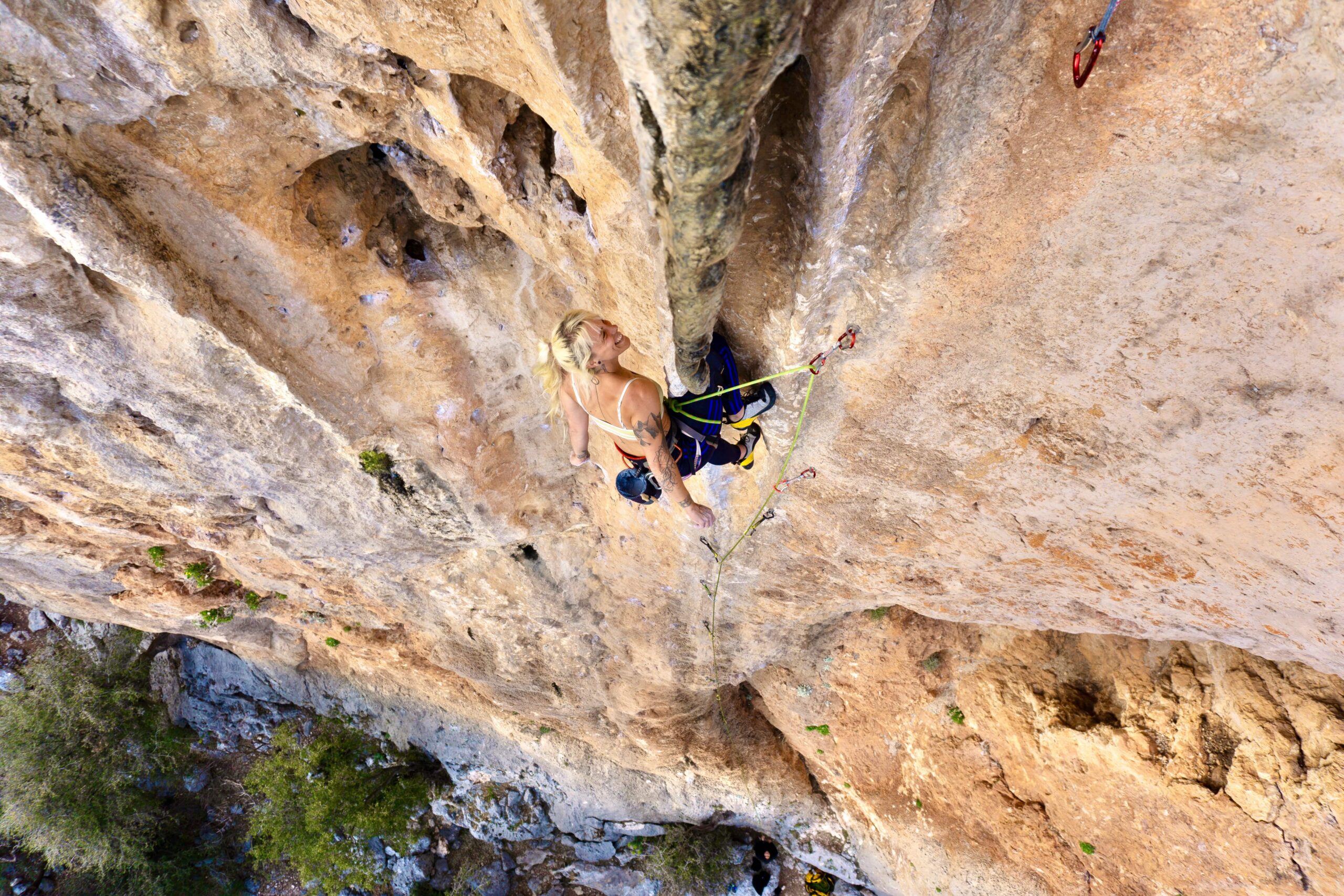 Climber reaching for a hold on an overhanging rock face